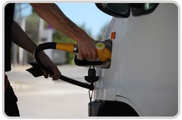 A person filling a car with a gas pump